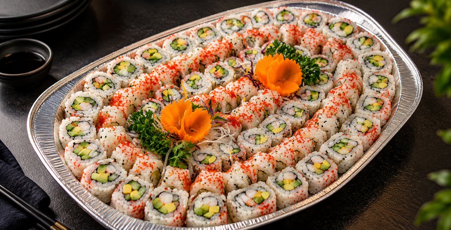 Cateringfat med maki, pyntet med gulrotroser og persille.